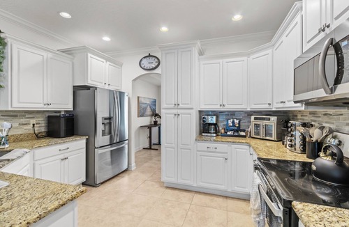 Fort Walton Beach House | Escape to your Fort Walton Beach oasis! High-end 4BR home sleeps 8 with a resort backyard: heated pool with jets, 5-star outdoor kitchen, pizza oven, theater TV, and fire pit. Near top beaches, featuring chic coastal decor and keyless check-in.