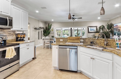 Fort Walton Beach House | Escape to your Fort Walton Beach oasis! High-end 4BR home sleeps 8 with a resort backyard: heated pool with jets, 5-star outdoor kitchen, pizza oven, theater TV, and fire pit. Near top beaches, featuring chic coastal decor and keyless check-in.
