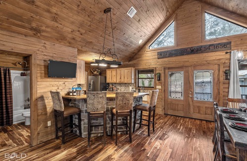 Shreveport House | Relax at this lakefront log cabin on private Emerald Isle, designed for easy outdoor living. Enjoy the hot tub, paddle out with kayaks and canoes, gather around the fire pit, or grill and unwind by the water.