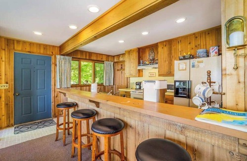 Lake Township House | Rustic dream-home w/lake views, wraparound deck, & wood-burning fireplace